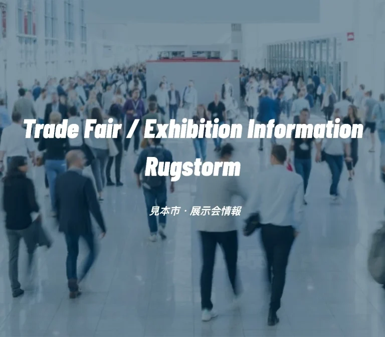 Blurred, high-angle view of a large crowd of professional attendees walking down the wide aisle of a convention center, overlaid with the text "Trade Fair / Exhibition Information Rugstorm".